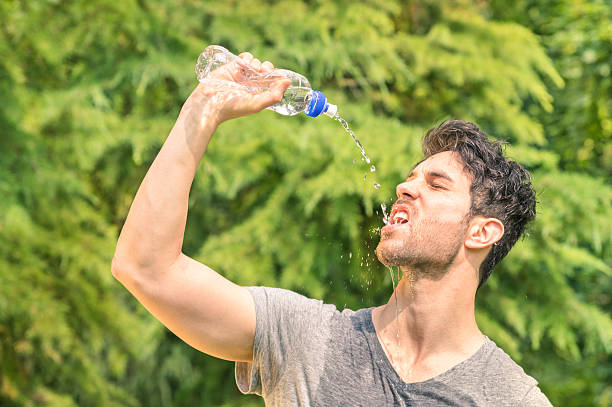 istock Sporty man refreshing with water after run training in park 527693229