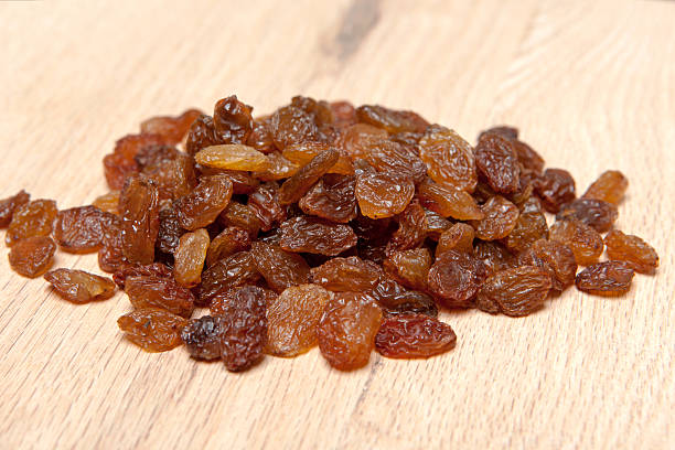 istock Raisins on wood plank, background 527693429