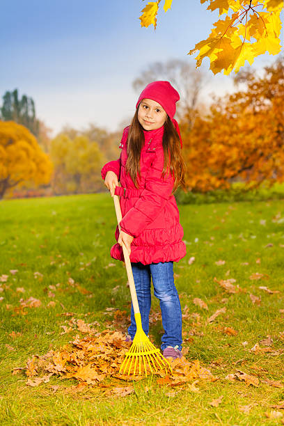 istock Beautiful small girl works with yellow rake 527694679