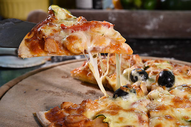 istock Pizza lifting slice on wooden board 527697397