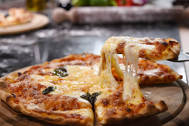 istock Pizza lifting slice on wooden board 527700847