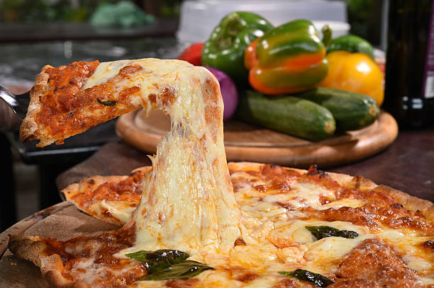istock Pizza lifting slice on wooden board 527701719