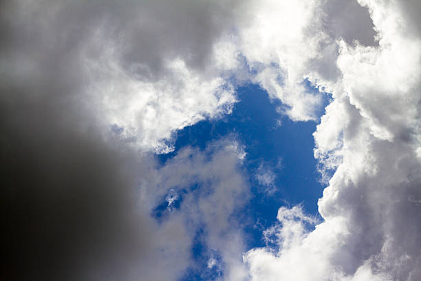 istock Black and White Clouds Around a Circle of Blue Sky 527703435