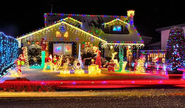 A beautiful display of Christmas lights brighten a dark snowy evening.