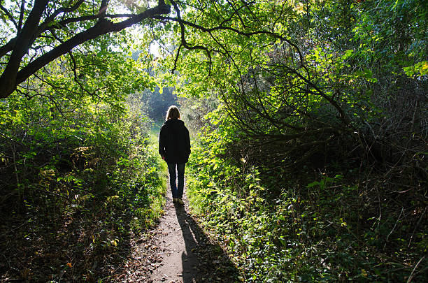 istock Woman walking at a backlit footpath 527704789