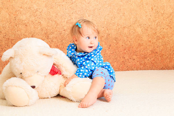 istock little girl playing with teddy bear 527707211