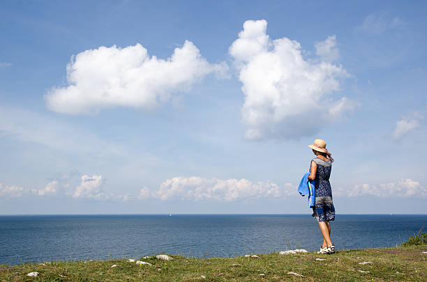 Woman on the go to the beach for a bath with a towel at her arm