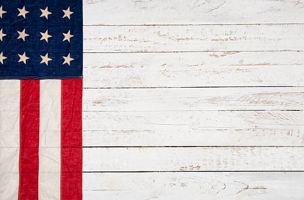 istock white wooden background with an American flag 527708355