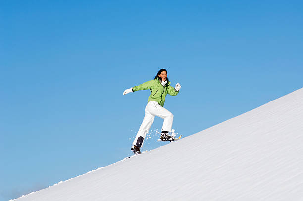 istock Woman running uphill with snowshoes 527708605