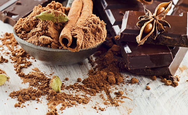 istock Broken chocolate bar and cacao powder on  wooden table 527721943