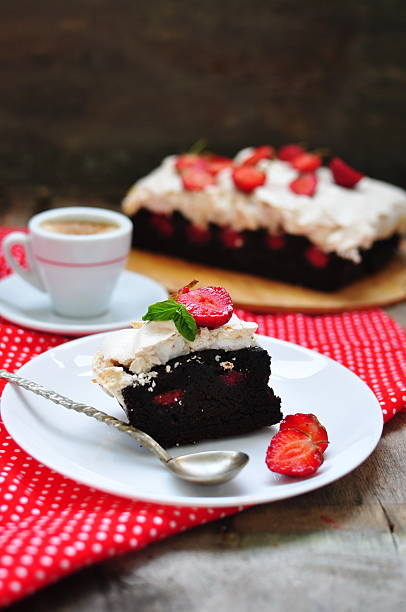 istock Chocolate brownies with meringue and strawberries, selective focus 527722205