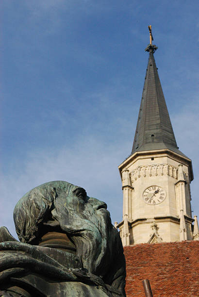 istock Brass statue and church tower 527722501