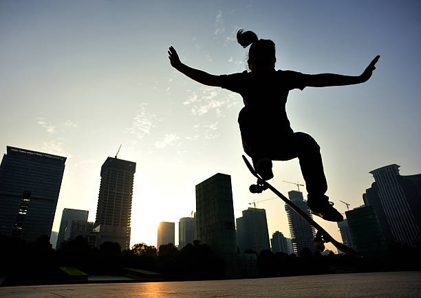 istock skateboarding woman jumping at  sunrise 527724217