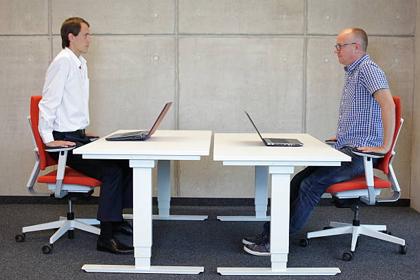 istock two coworkers exercising on armchairs at workstations in office 527726971