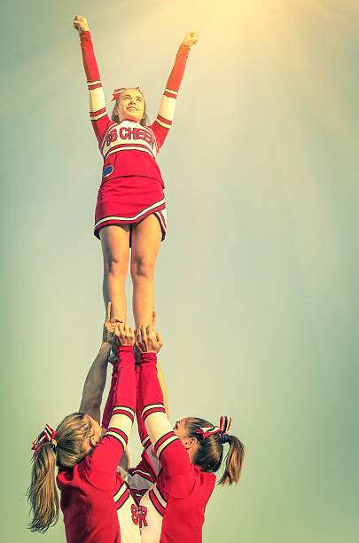 Cheerleaders in action on a vintage filtered look Cheerleaders in action on a vintage filtered look - Concept of unity and team sport - Training at college high school with young female teenagers cheerleader photos stock pictures, royalty-free photos & images