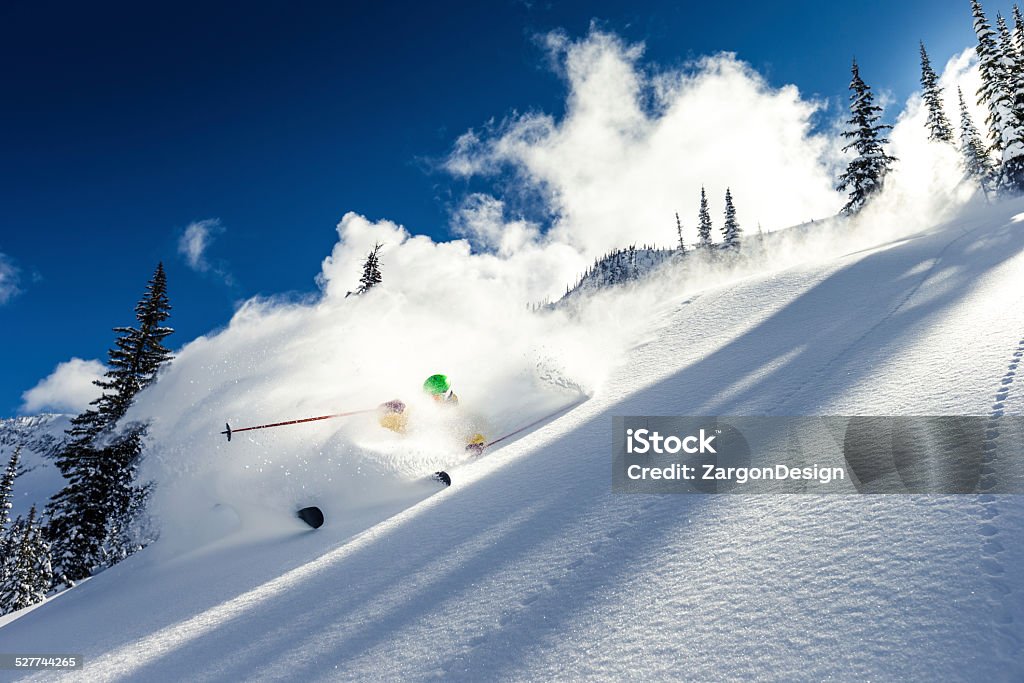 heli skiing Male skier making turn on powder slope. Powder Snow Stock Photo