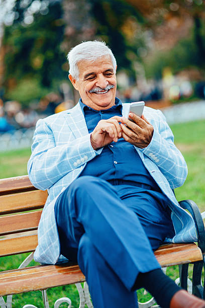 istock Senior man with smart phone smiling outdoors 527745261