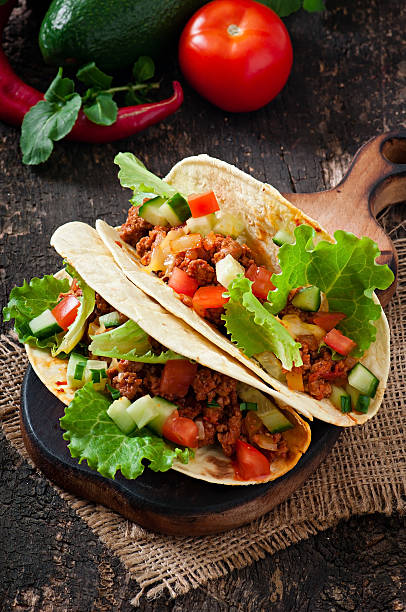 istock Mexican tacos with meat, vegetables and cheese 527760939