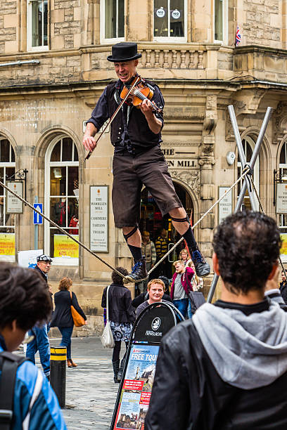 artista ambulante en la cuerda mientras tocando el violín - tightrope walking circus skill fotografías e im�ágenes de stock