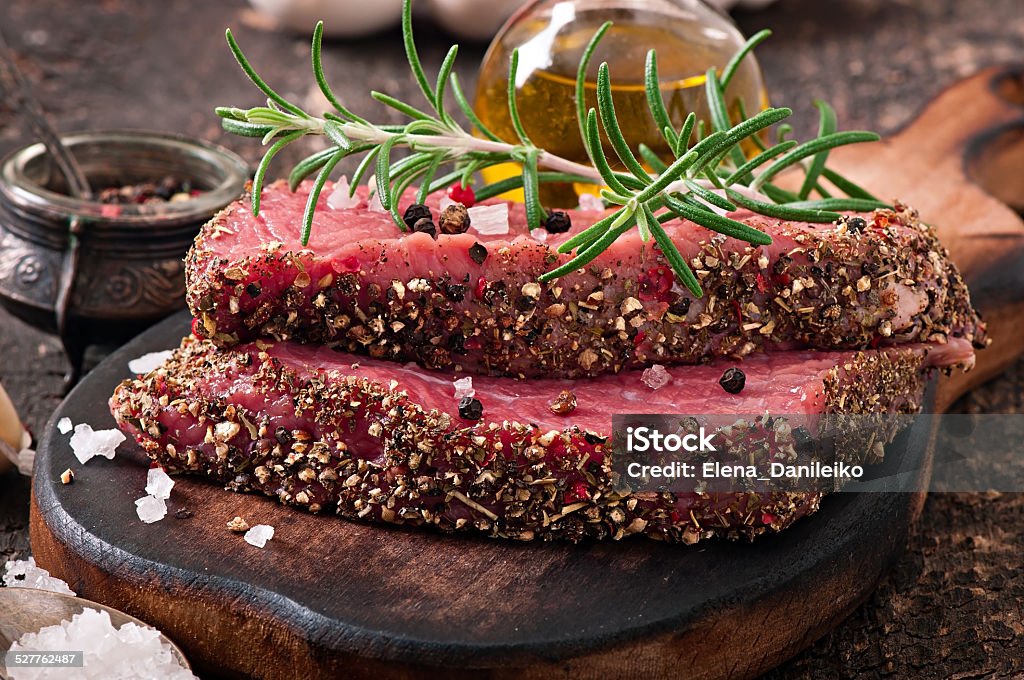 Raw beef steak with spices and a sprig of rosemary Beef Stock Photo