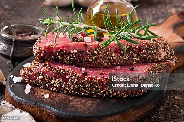 Raw Beef Steak With Spices And A Sprig Of Rosemary Stock Photo - Download Image Now - Beef, Blood, Close-up
