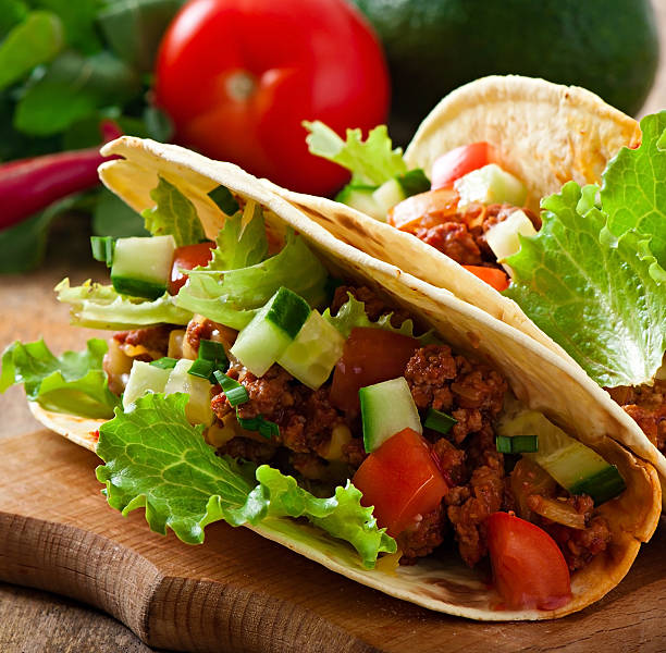 istock Mexican tacos with meat, vegetables and cheese 527763601