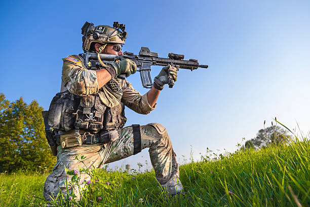 American Soldier aiming his rifle on blue sky background stock photo