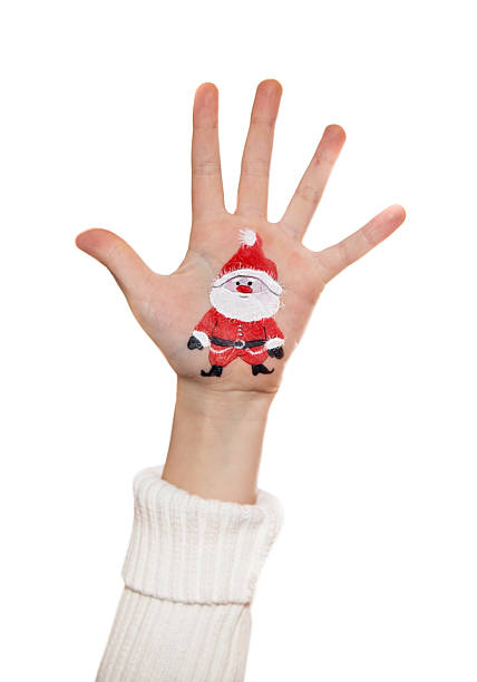 istock Kid's hands with painted Christmas symbol. Santa 527785157
