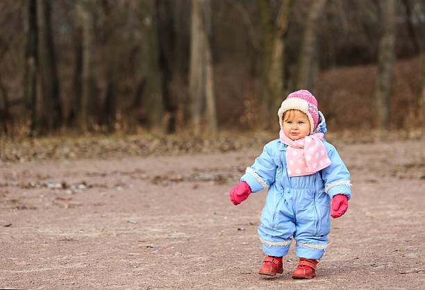 petite fille faire le premier pas dans le parc - baby first steps autumn child photos et images de collection
