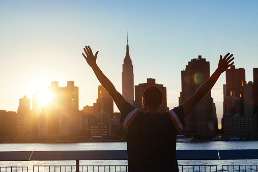 Successful Man with New York Skyline on Background at Sunset