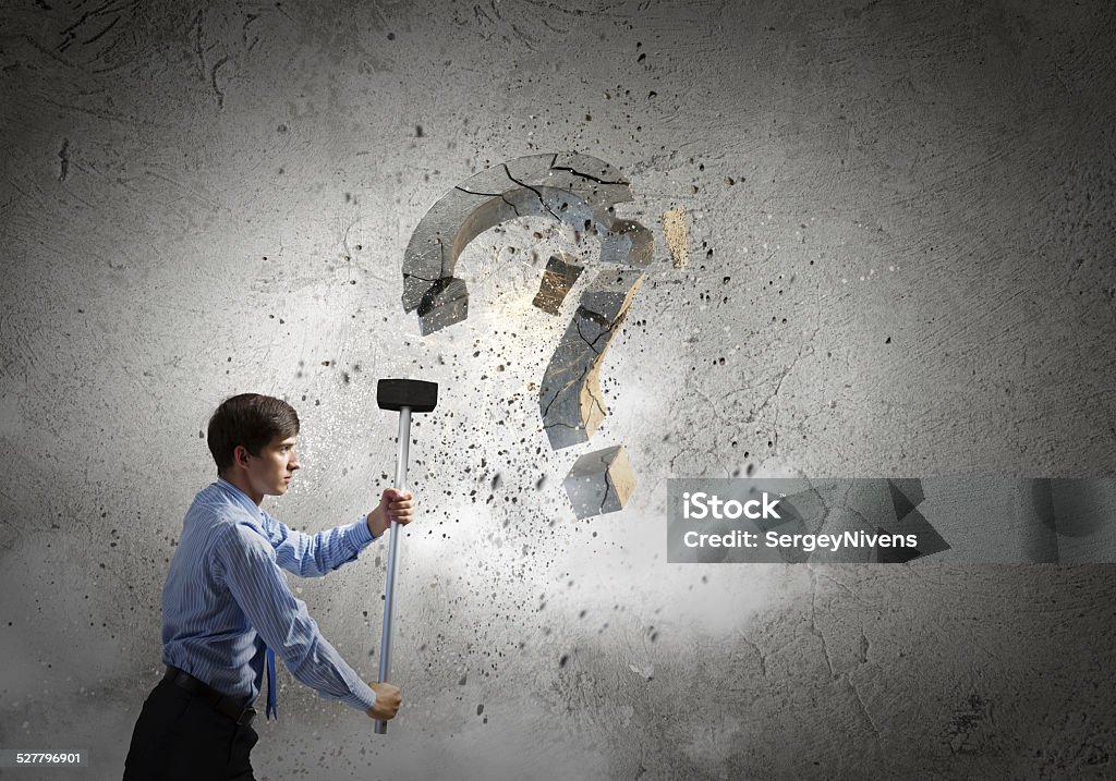 Determined businessman Young pretty businessman crashing stone question symbol Asking Stock Photo