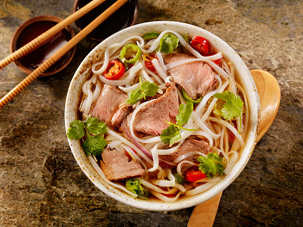 Beef Pho Grilled Beef and Rice noodle soup with Carrots, Onions, Peppers and Cilantro -Photographed on Hasselblad H1-22mb Camera noodle soup photos stock pictures, royalty-free photos & images