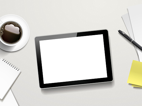 tablet and working place elements over white table