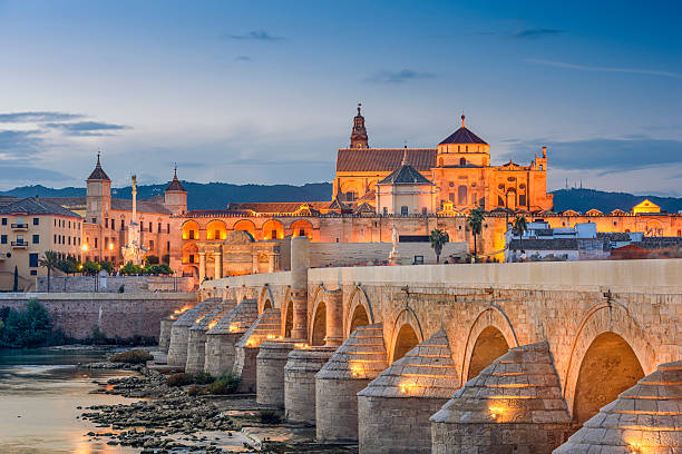 Cordoba, Spain at the Roman Bridge and Mosque-Cathedral Cordoba, Spain view of the Roman Bridge and Mosque-Cathedral on the Guadalquivir River. andalucia stock pictures, royalty-free photos & images