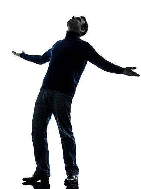 Businessman standing with arms raised on white background.