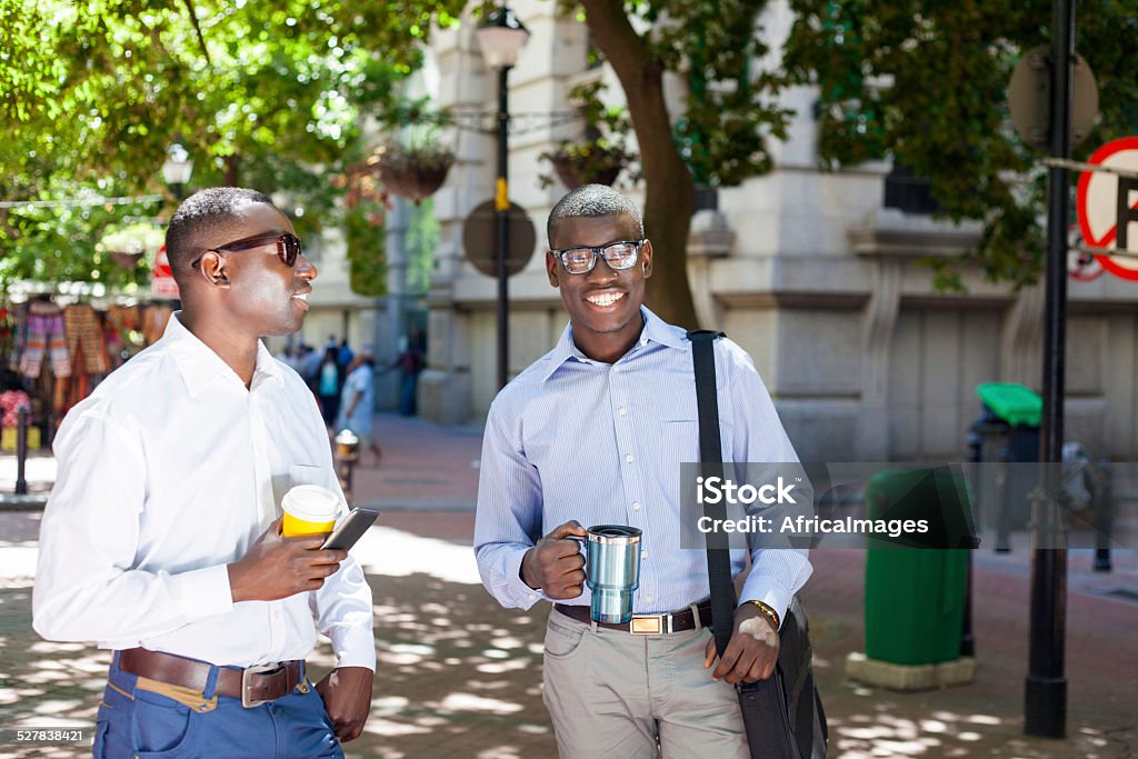 African men having coffee and conversation on their break. Two african males having a conversation while randomly sipping on their coffee. Cape Town, Western Cape, South Africa. 20-24 Years Stock Photo