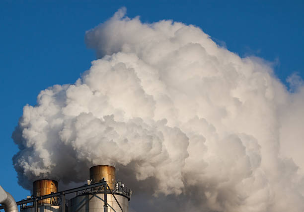 istock Smoke clouds from a chimney against blue sky. 527840273