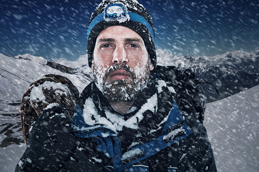 Adventure mountain man in snow expedition with climbing gear and determination