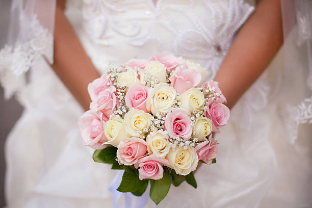 istock White and pink wedding bouquet with roses in bride's hands 527843095