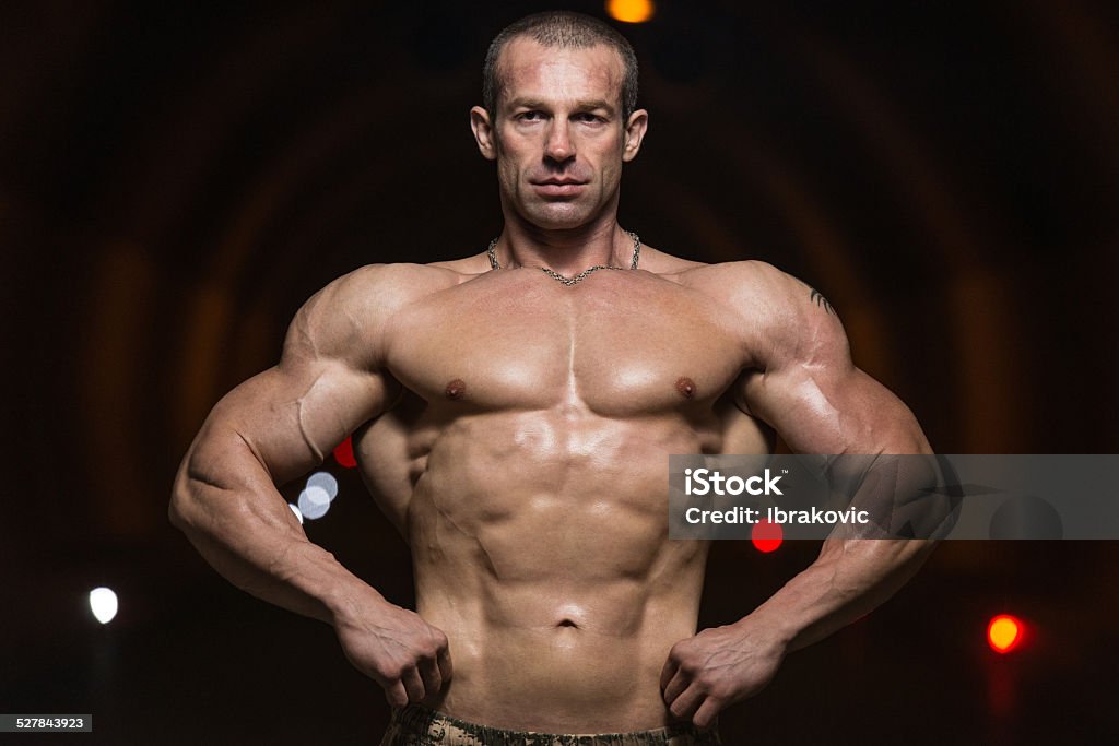 Bodybuilder Performing Front Lat Spread Poses In Tunnel Active Lifestyle Stock Photo