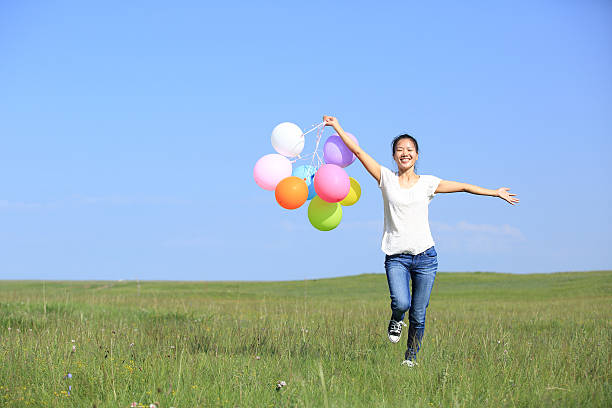 istock young asian woman  with colored balloons 527844805