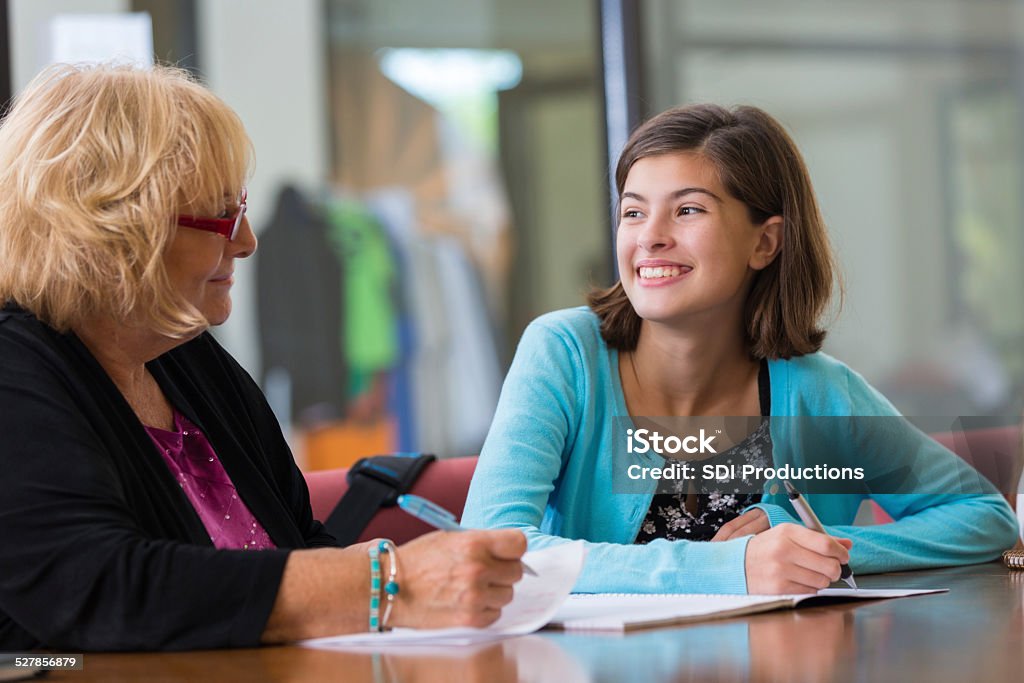 Tutor explaining homework assignment to preteen student Mental Health Professional Stock Photo