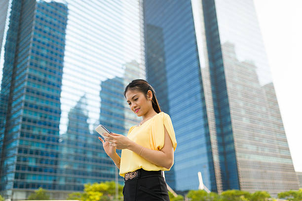 Asian woman reading text messages at outdoor stock photo