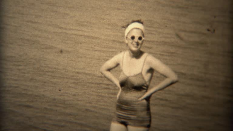 1938: Women in white round sunglasses and old timey bathing suit.