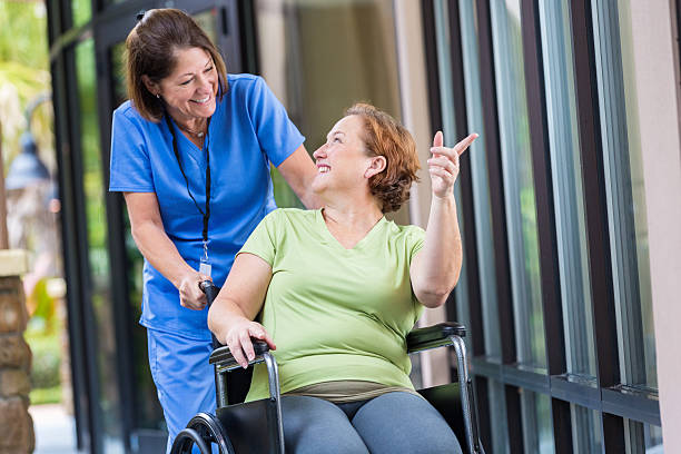 istock Patient directing nurse while being pushed in wheelchair down hallway 527857783