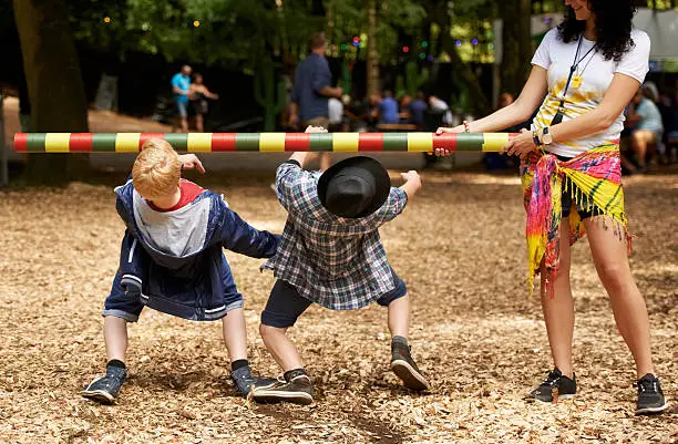 Shot of two kids doing the limbo at an outdoor festival