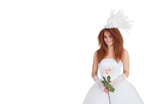 Portrait of elegant brunette in wedding dress holding rose over white background
