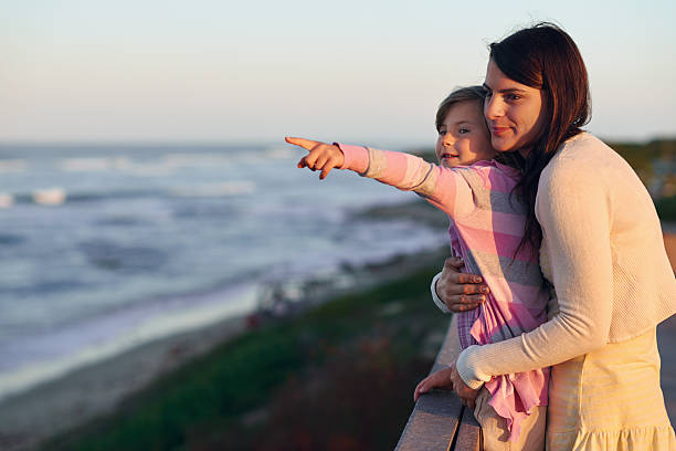 istock mom daughter beach 527861105