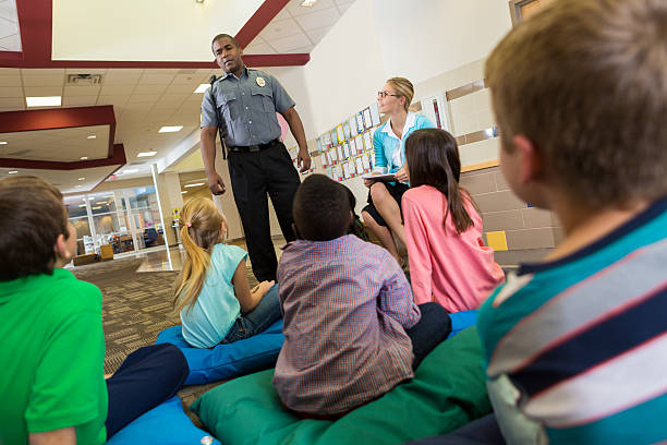 istock Police or school security officer speaking to young students 527863023