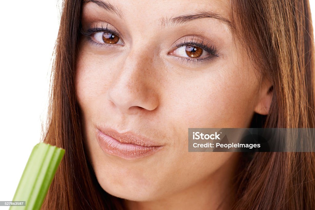 Chewing on some celery Portrait of an attractive young woman eating a stick of celery Eating Stock Photo